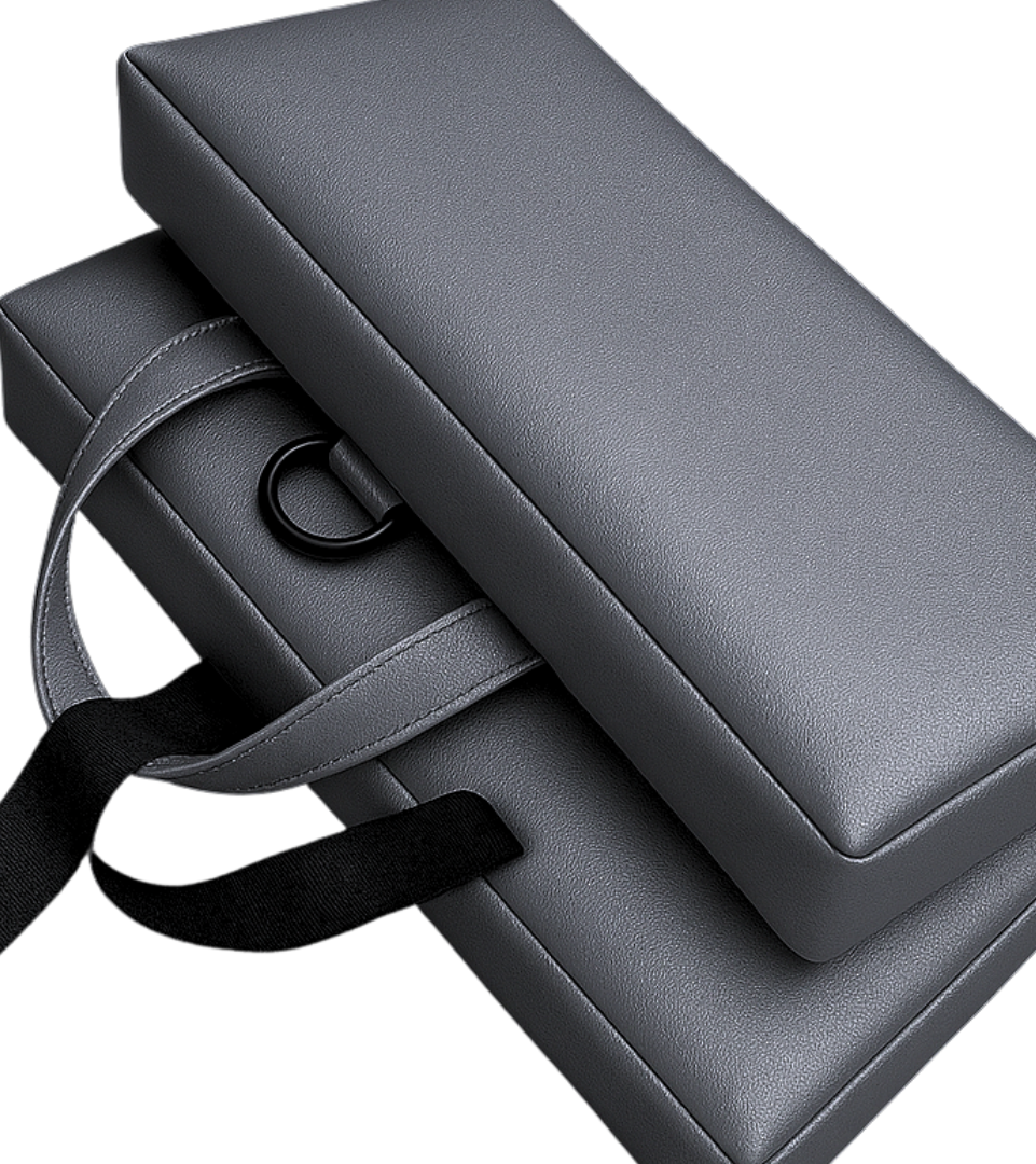 SunCloud® Travel Cushion in metallic gunmetal faux leather featuring black straps and D-rings, handcrafted design, and smooth reflective finish on a black background.