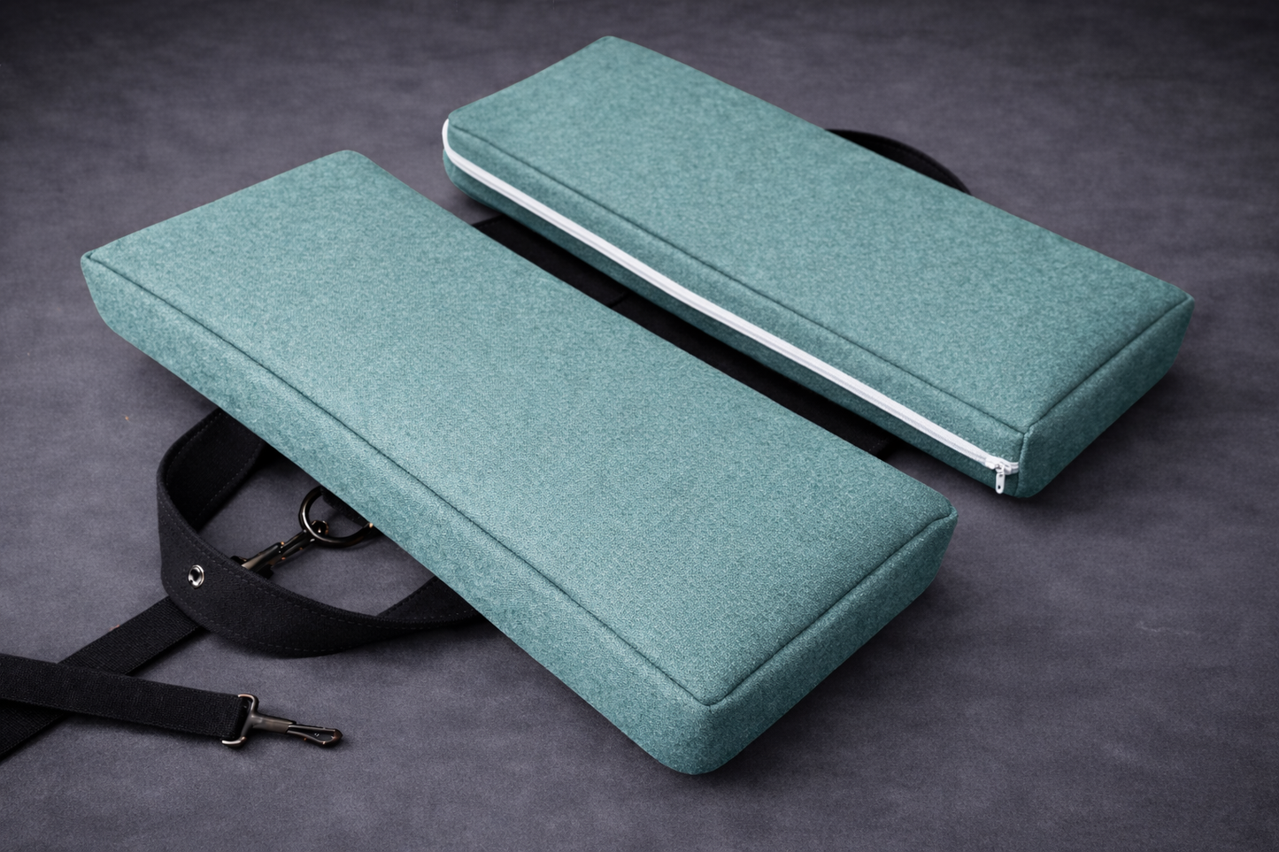 Bermuda green foldable travel seat cushion with slim white zipper and black adjustable strap, designed for pelvic and tailbone pressure relief