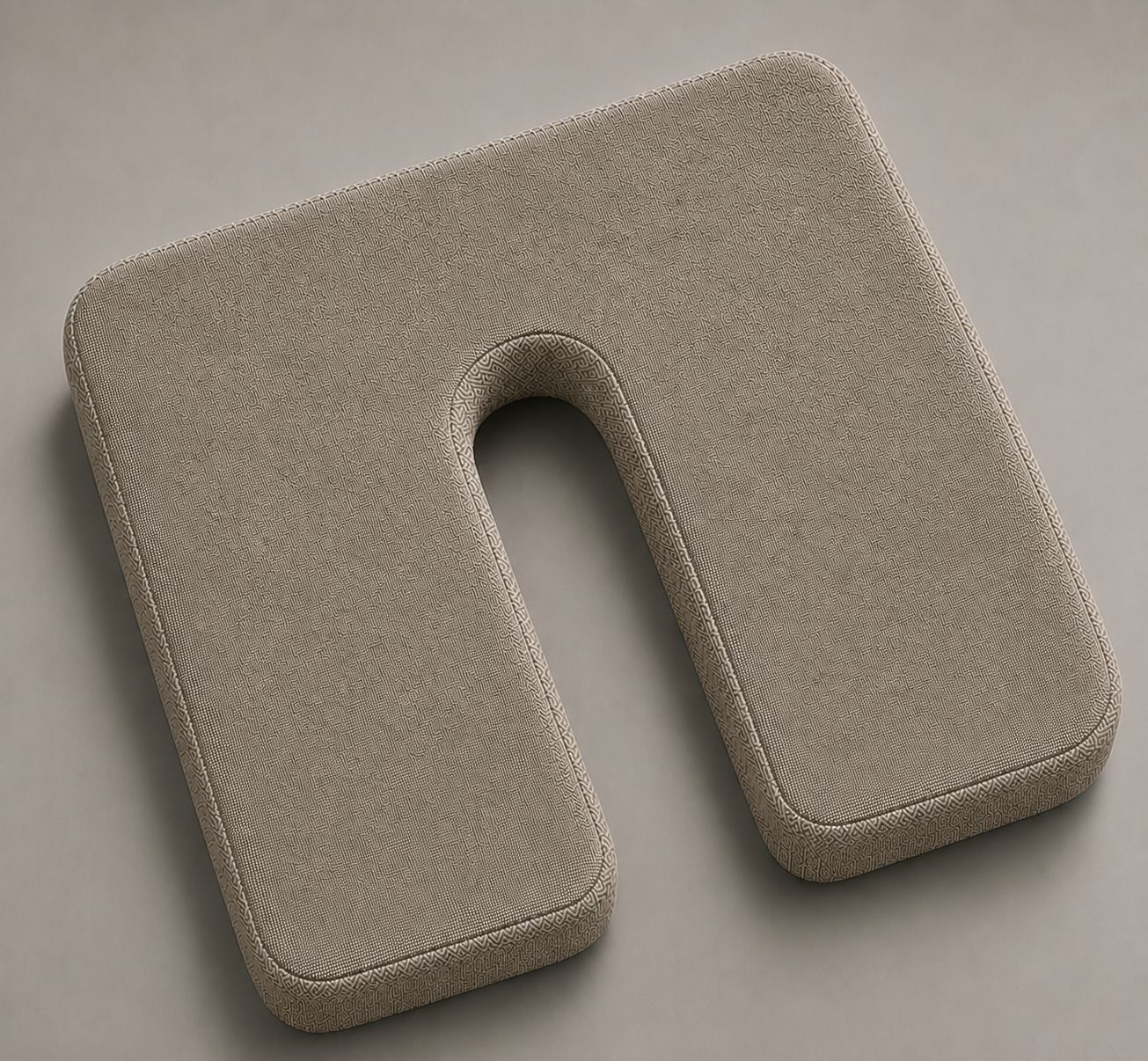 SunCloud® beige U-shaped coccyx seat cushion with centered black metal D-rings, smooth linen-style fabric, and tailbone relief cutout on a soft gray background.