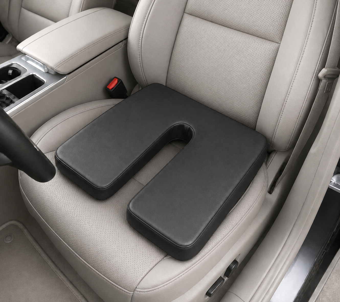 SunCloud black faux leather U-shape coccyx seat cushion on a car seat with tailbone cutout for pressure relief and long-sitting comfort.