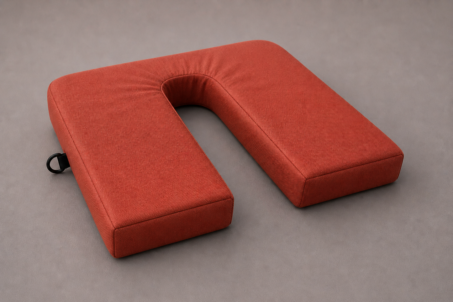 Burnt orange U-shape coccyx cushion in durable canvas fabric designed for tailbone and pelvic pressure relief on firm seating