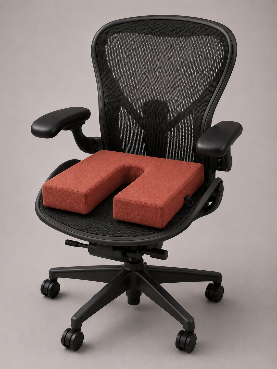 Black office chair with red cushion on a neutral background